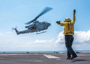 160626-N-JW440-229 ATLANTIC OCEAN (June 26, 2016) Aviation Boatswain's Mate (Handling) 3rd Class Markgerald Zagala signals an AH-1W Super Cobra to land aboard the amphibious assault ship USS Wasp (LHD 1). Wasp is deployed with the Wasp Amphibious Ready Group to support maritime security and theater security cooperation efforts in the U.S. 5th and 6th Fleet areas of operation. (U.S. Navy photo by Mass Communication Specialist 3rd Class Rawad Madanat/Released)