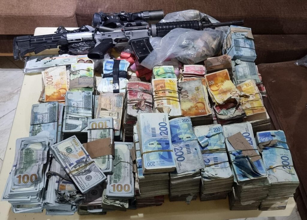 Δεσμίδες μετρητών σε σέκελ, δολάρια και άλλα νομίσματα μαζί με δύο τυφέκια σε επίσημη φωτογραφία των IDF