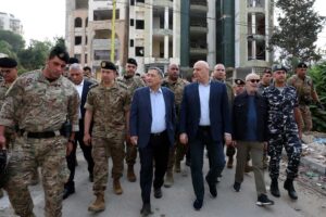 Ο πρόεδρος του Λιβάνου Ζοζέφ Αούν περπατά με στρατιωτικούς και στελέχη ασφαλείας μπροστά από κτίριο με ζημιές στη Ναμπατίγια