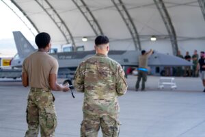 Δύο Αμερικανοί αεροπόροι παρακολουθούν μη επανδρωμένο αεροσκάφος Fury μέσα σε υπόστεγο στη βάση Κριτς