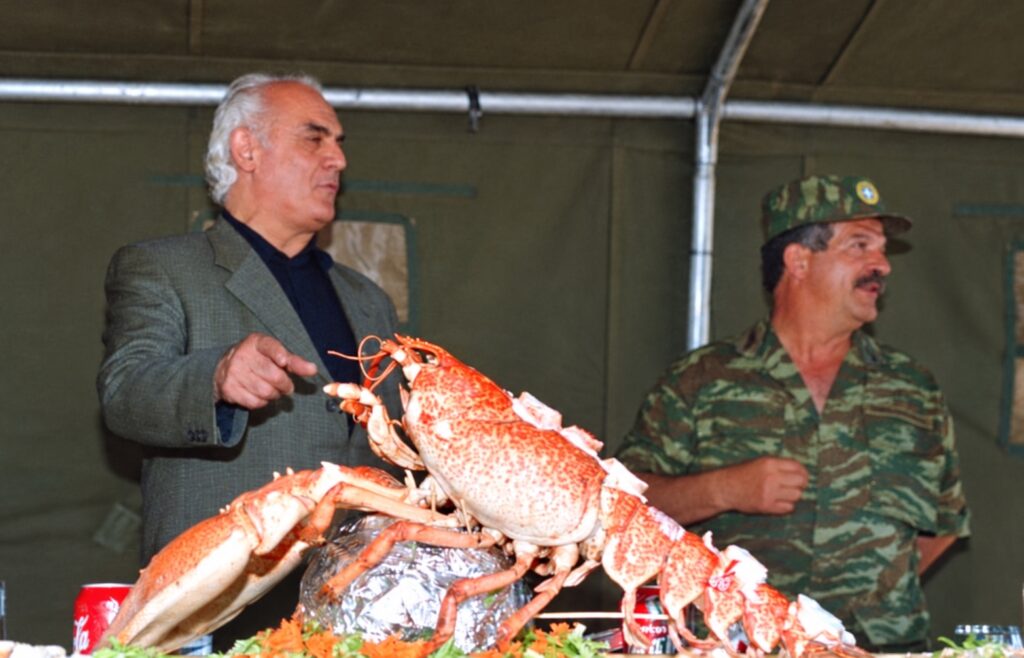 Αρχειακή φωτογραφία δύο ανδρών δίπλα σε τραπέζι με αστακό, μέσα σε στρατιωτική σκηνή