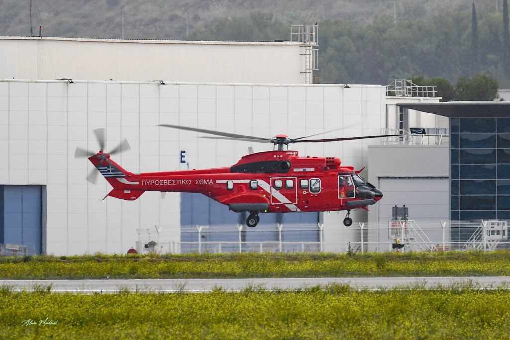 Κόκκινο Airbus H215 με ελληνική σημαία και επιγραφή Πυροσβεστικό Σώμα σε χαμηλή πτήση στο Marignane