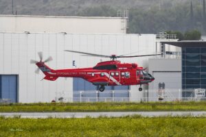 Κόκκινο Airbus H215 με ελληνική σημαία και επιγραφή Πυροσβεστικό Σώμα σε χαμηλή πτήση στο Marignane