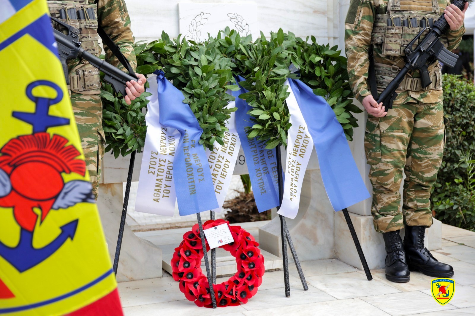 Στεφάνια στη βάση του μνημείου ανάμεσα σε δύο άνδρες της τιμητικής φρουράς