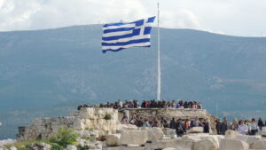 Η ελληνική σημαία στον ιστό της Ακρόπολης πάνω από τους επισκέπτες του Ιερού Βράχου