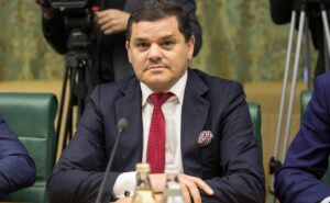 Ο Αμπντουλχαμίντ Ντμπεϊμπά καθιστός με σκούρο κοστούμι και κόκκινη γραβάτα