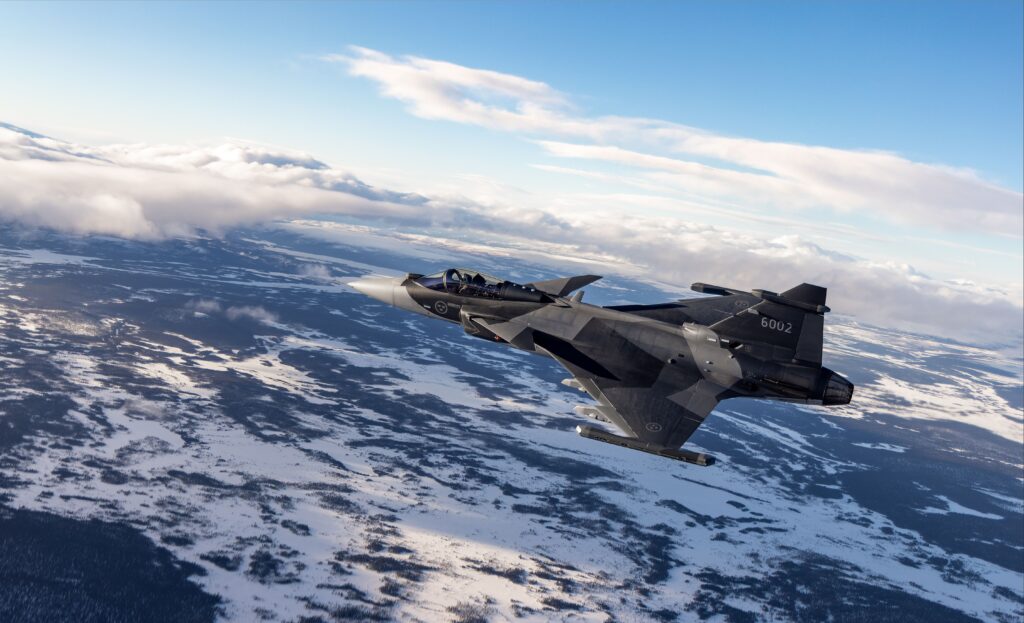 Μαχητικό Gripen E με αριθμό 6002 σε πτήση πάνω από χιονισμένο τοπίο